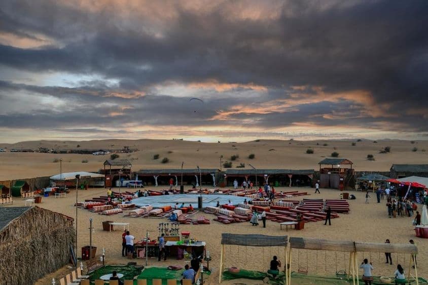 Puesta de sol sobre un campamento beduino tras safaris tradicionales en Dubái.