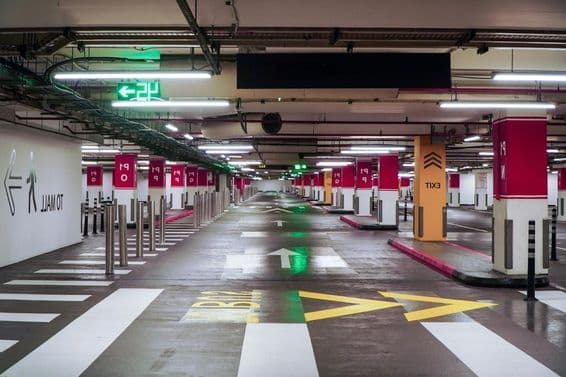 Un espacioso y moderno estacionamiento en Dubái con iluminación brillante y señalización clara.