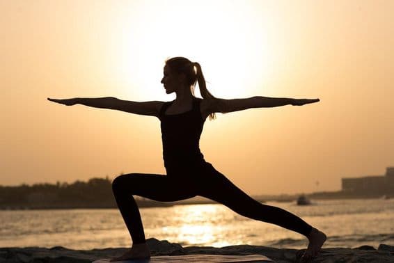 Una mujer practicando yoga al atardecer en Dubái.