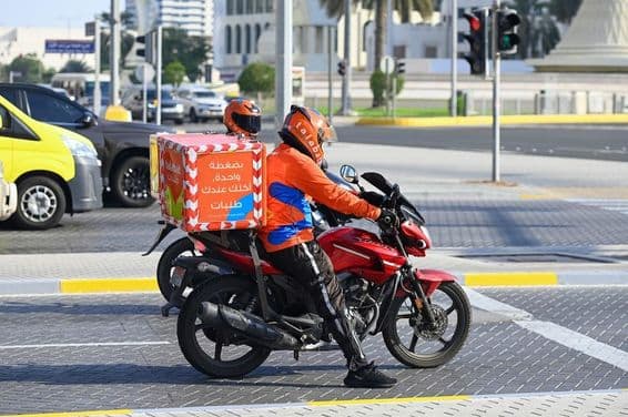 Repartidores de la empresa de comida a domicilio Talabat en una calle de Abu Dabi.
