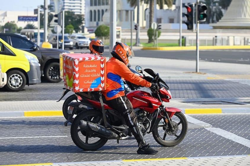 Repartidores de la empresa de comida a domicilio Talabat en una calle de Abu Dabi.