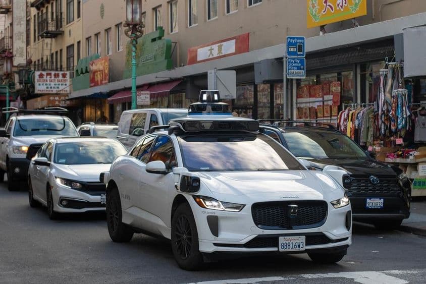 Robotaxi de Waymo navegando por las concurridas y estrechas calles de Chinatown en San Francisco.
