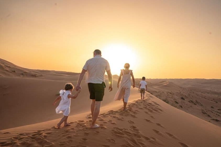 Una familia disfrutando del atardecer en el desierto.