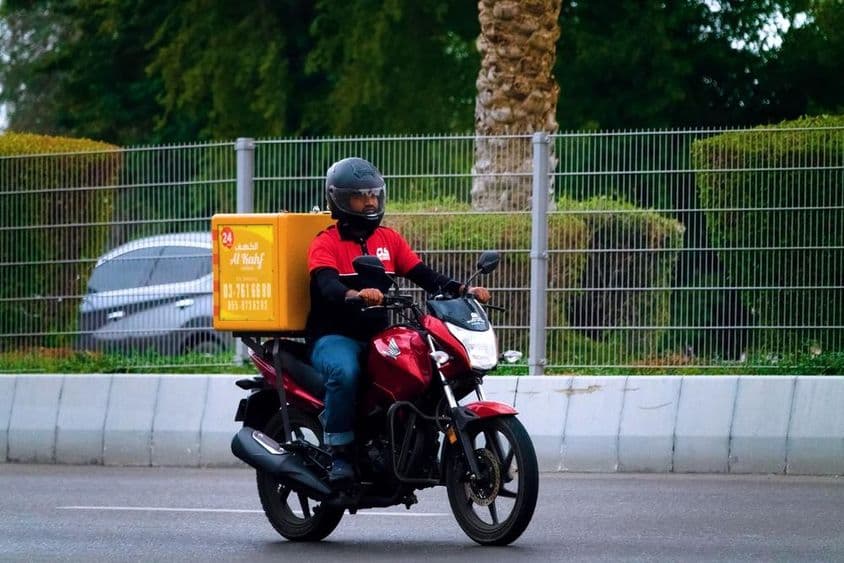 Entrega de comida por mensajero en motocicleta en Dubái.