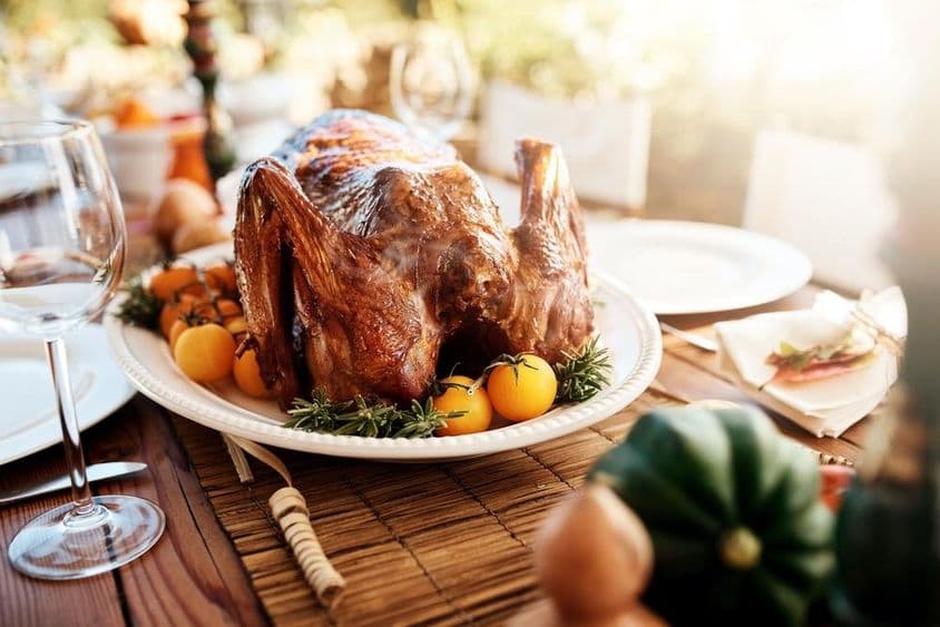 Comida de pavo de Acción de Gracias estadounidense con verduras en una mesa al aire libre.