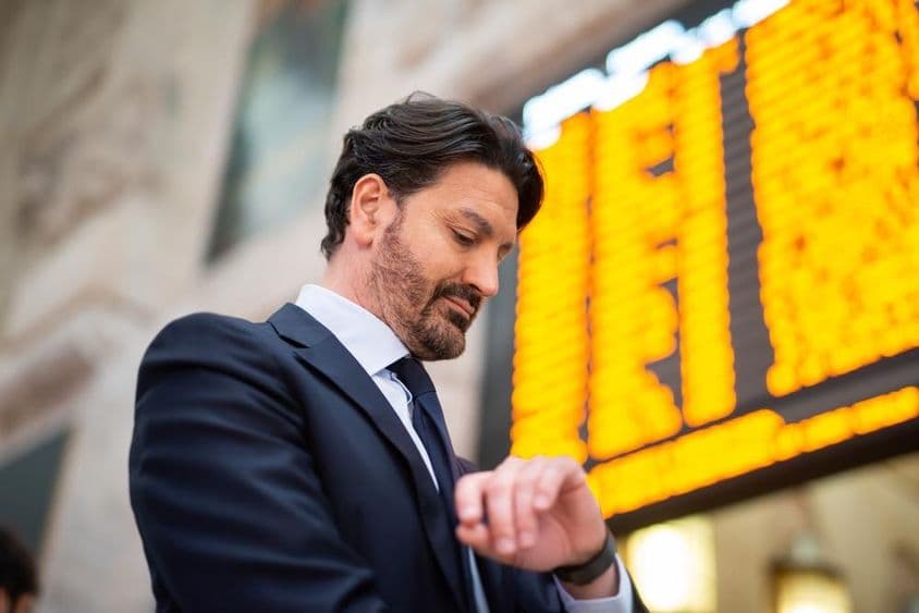 Un viajero consulta el horario frente a un itinerario.