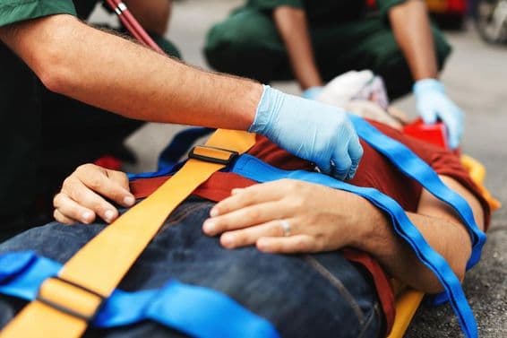 Personal de servicios de emergencia asiste a una persona herida en una camilla.
