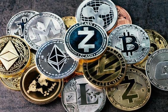 Criptomoneda, varias criptomonedas físicas plateadas y doradas brillantes.