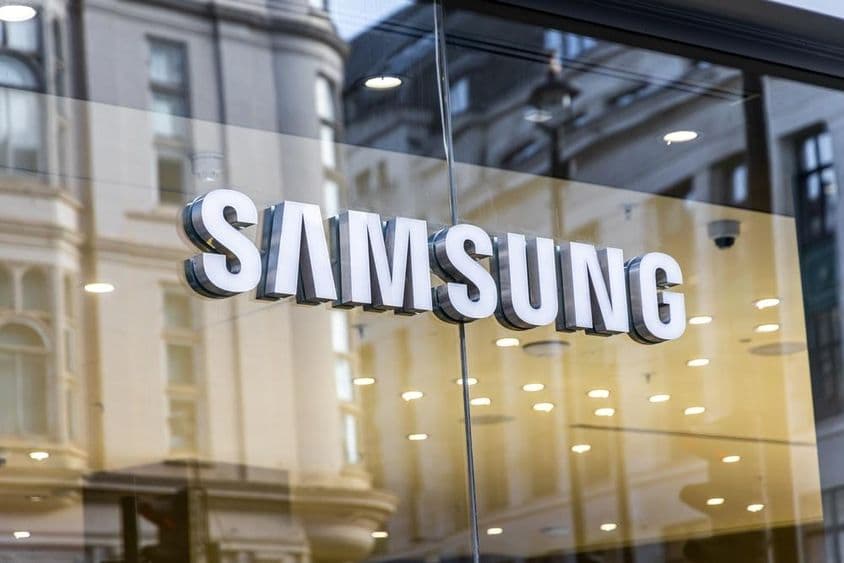 Logotipo de la marca tecnológica Samsung en ventana de vidrio.
