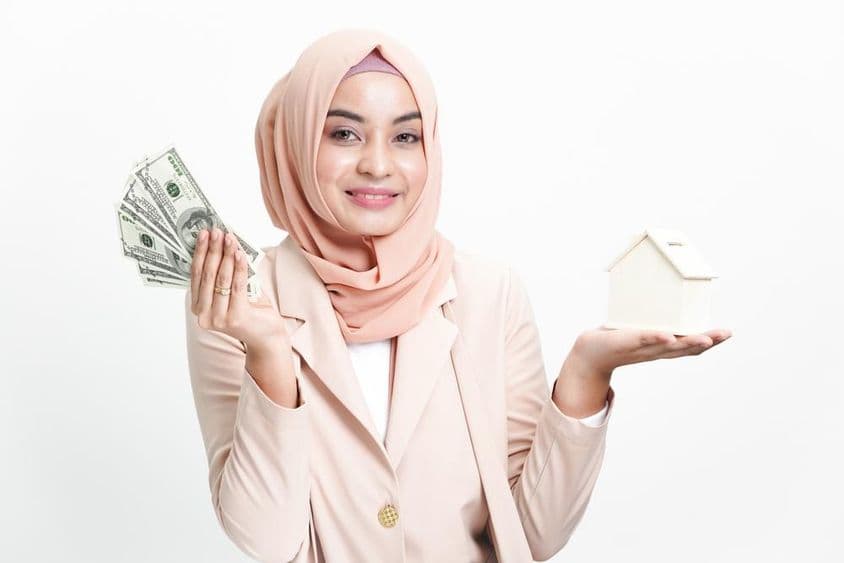 Empresaria musulmana sosteniendo dinero para compra de casa.