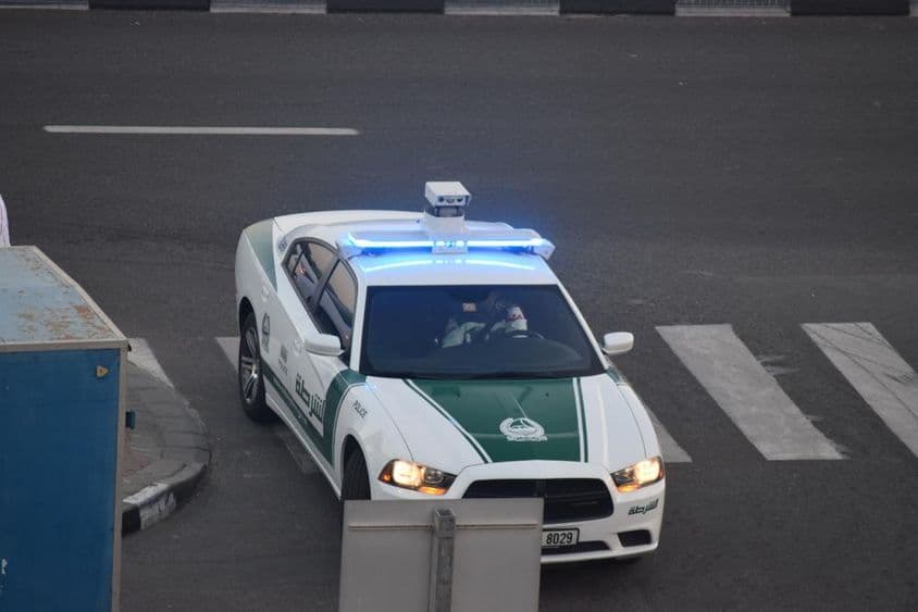 Un coche de policía de Dubái conduciendo por la calle.
