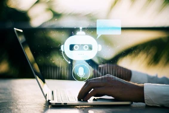 Una persona escribiendo en un portátil con un fondo exterior borroso que presenta un ícono de chatbot.