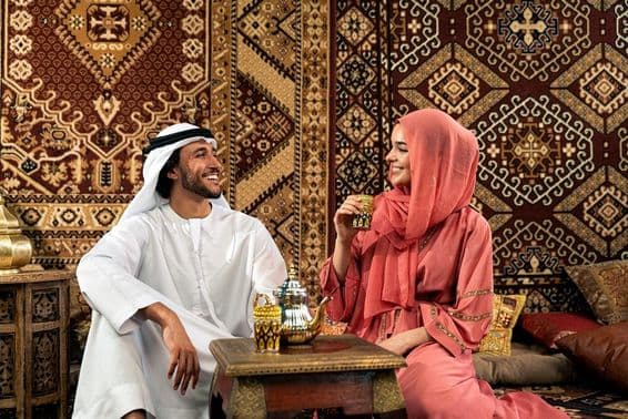 Pareja de emiratíes jóvenes pasando tiempo en un café árabe tradicional.