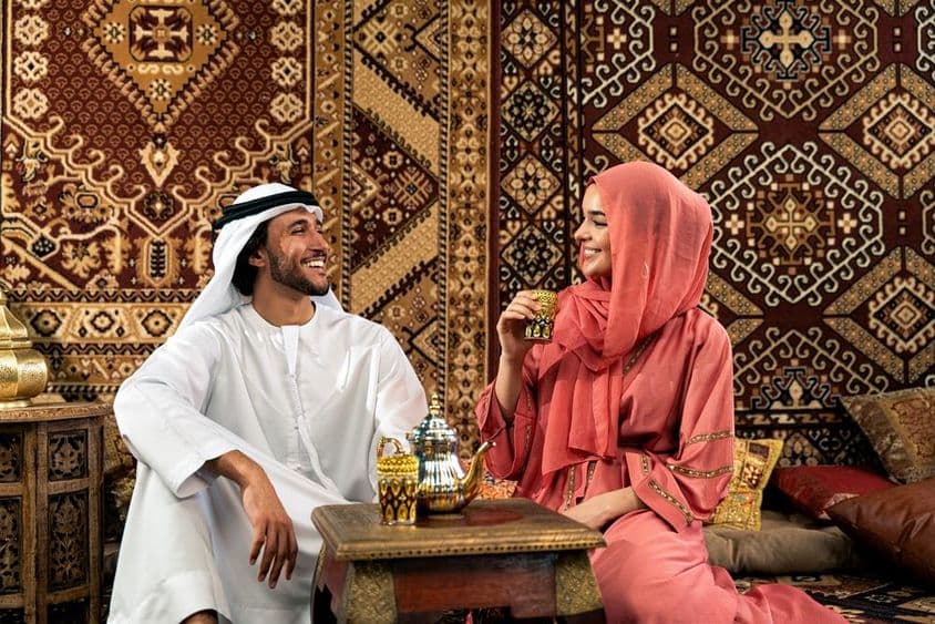 Pareja de emiratíes jóvenes pasando tiempo en un café árabe tradicional.