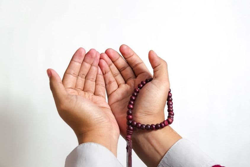 Musulmán rezando con cuentas de oración.