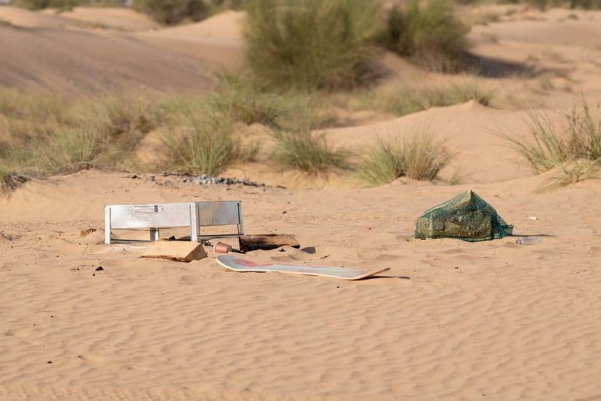 Metal, plástico y otros desechos dejados por personas contaminan el entorno desértico en Dubái.
