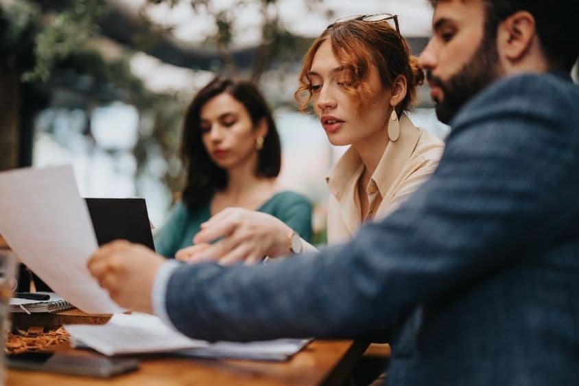 Empresarios de startups centrados en planificar y discutir estrategias en un café informal.
