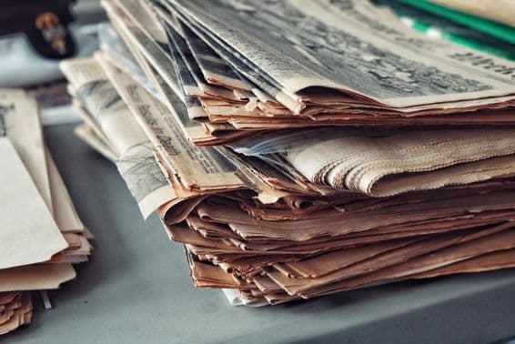 Periódicos viejos apilados con telarañas.