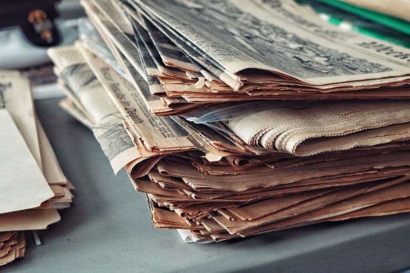 Periódicos viejos apilados con telarañas.