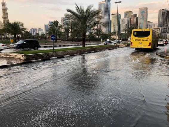 Tráfico circulando por una carretera urbana inundada en Dubái.