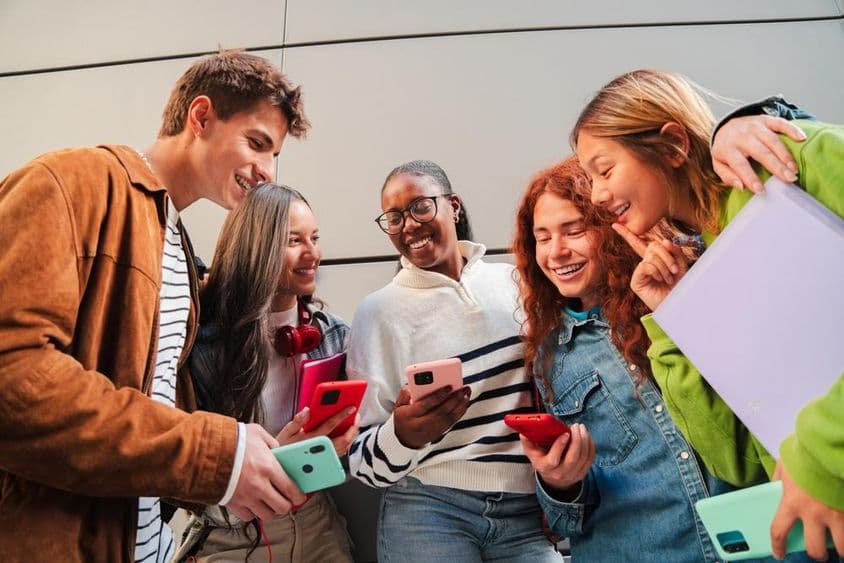 Estudiantes usando teléfonos durante un descanso.
