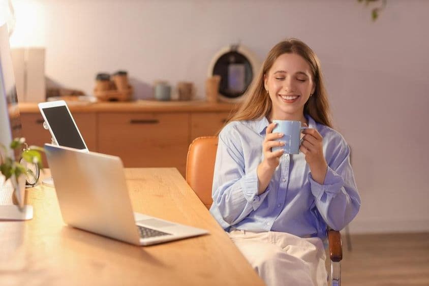 Joven empresaria bebiendo café en la oficina por la noche.