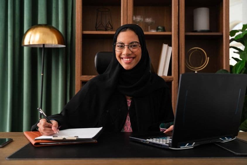 Empresaria en Dubái vistiendo abaya en una oficina.