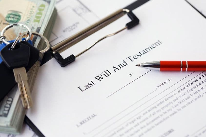 Pluma y llaves sobre un formulario de testamento.
