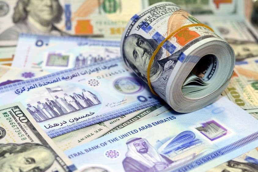 Billetes de 100 dólares estadounidenses y dirhams.