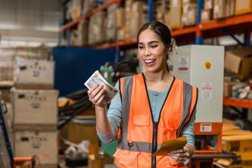 Empleado del almacén feliz con un aumento salarial.