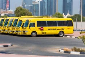 Una fila de autobuses escolares amarillos en Dubai estacionados afuera.