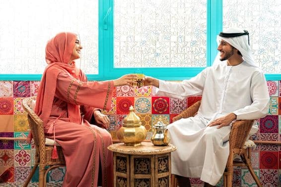 Joven pareja emirati pasando tiempo en un café árabe tradicional.
