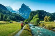 Grupo de turistas caminando a lo largo de un río en un bosque en el cantón de Berna, Suiza.