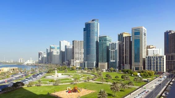 Amplio césped y vista a laguna serena en Al Majaz Waterfront.