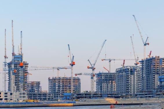 Construcción de bienes raíces en Dubai Creek Harbor, grúas, torres sin terminar.