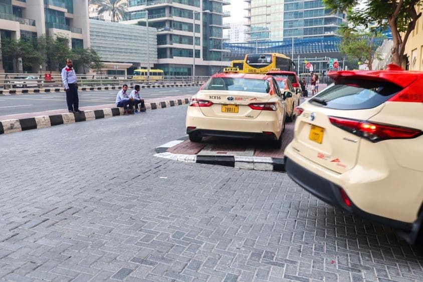 Un grupo de conductores de taxi esperando pasajeros fuera de un hotel en Dubai.
