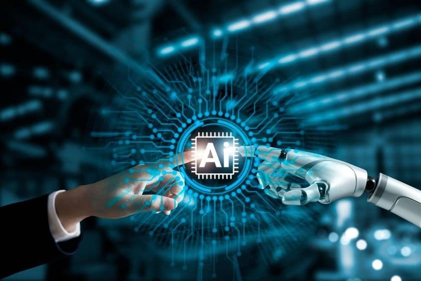 Manos de robot y humano conectan placa de circuito de IA.