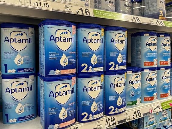 Polvo de leche Aptamil en estantes de supermercado.