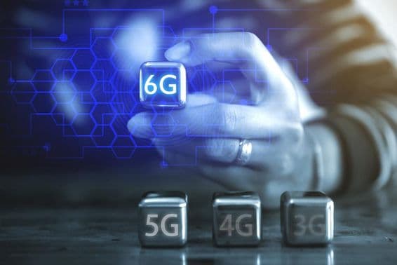 Un joven empresario usando una bola de acero en forma de cubo, viendo la leyenda: 6G.