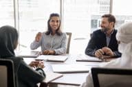 mujer de negocios hablando con socios árabes.
