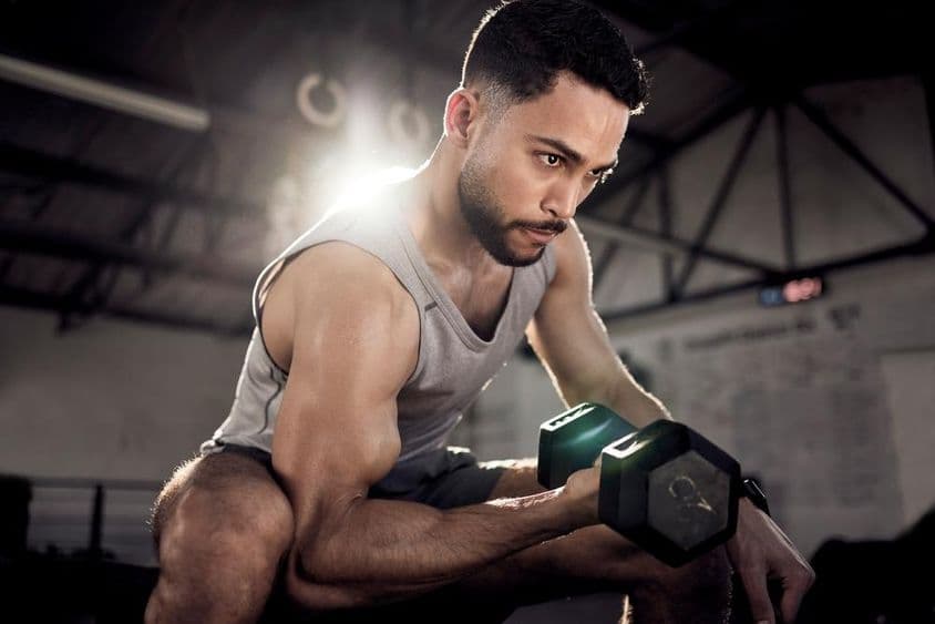 Un atleta árabe realizando levantamiento de pesas o ejercicios de bíceps en Dubái.