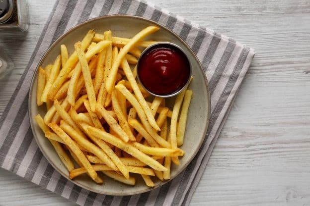 Papas fritas caseras y ketchup en un plato.