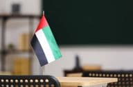 La bandera de los Emiratos Árabes Unidos sobre un escritorio en el aula