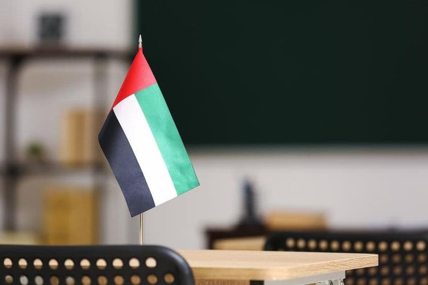 La bandera de los Emiratos Árabes Unidos sobre un escritorio en el aula