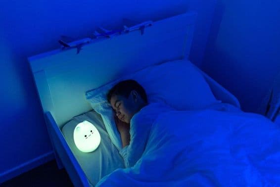 niño durmiendo con lámpara LED de cabecera.