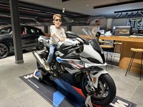 Niño con gafas de sol sentado en una motocicleta BMW.