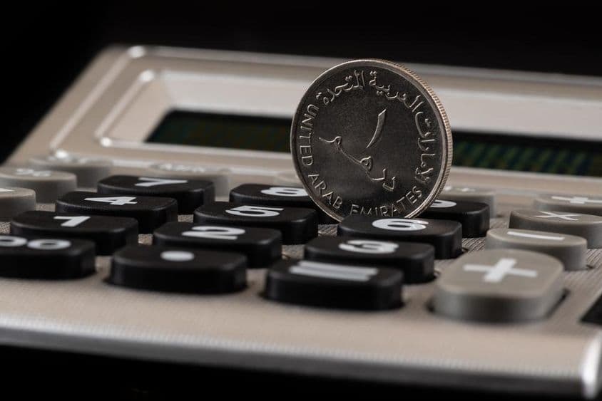 Moneda de 1 dírham de los Emiratos Árabes Unidos y calculadora