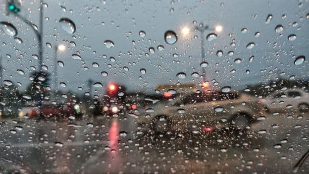 Gotas de lluvia sobre un fondo borroso vistas desde la ventana de un coche
