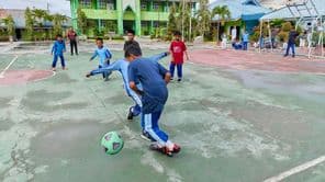 Estudiantes de primaria jugando al fútbol