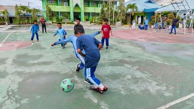 Estudiantes de primaria jugando al fútbol